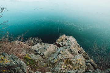 rocks from above with view to a frozen lake