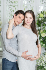 Fototapeta premium Happy pregnant woman with husband posing at home