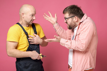 An angry client gesticulates with hands, swears and shouts at the worker, who innocently looks at...