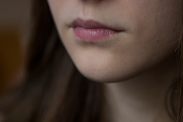 lips of a very young girl with long hair, part of the face mouth