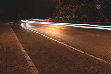 Car light tracks under tree bypass lights at night
