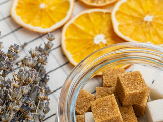 Lumpy instant sugar, a bouquet of lavender and slices of dried lemon on a checkered tablecloth