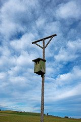 Perch for birds of prey with a birdhouse in the Bavarian countryside