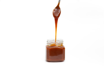 Caramel in a jar on a white background