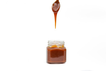 Caramel in a jar on a white background