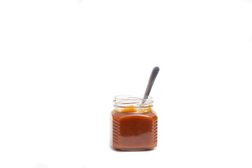 Caramel in a jar on a white background