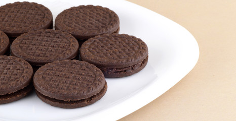 Brown chocolate sandwich biscuits with cream filling in plate