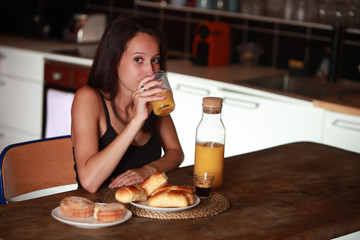 Jolie jeune femme Brune prenant son petit déjeuner