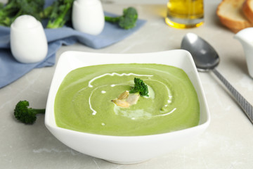 Delicious broccoli cream soup served on grey marble table