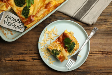 Tasty broccoli casserole served on wooden table, flat lay