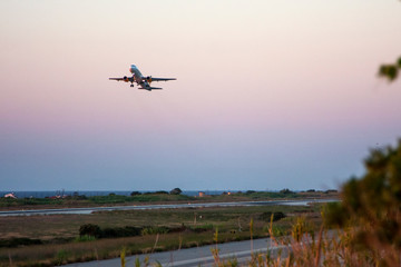 airplane taking off at sunset