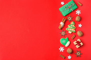 Fototapeta na wymiar Flat lay composition with Christmas decorations and treats on red background, space for text. Winter holidays
