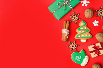 Flat lay composition with Christmas decorations and treats on red background, space for text. Winter holidays