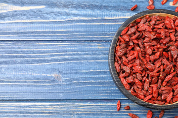Obraz na płótnie Canvas Dried goji berries on blue wooden table, top view. Space for text