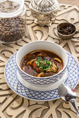 Uzbek noodle soup Lagman with noodles and lamb on oriental wooden table
