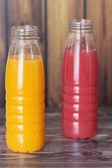 two bottles of milkshake on wooden wall background