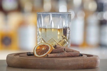 Hazy Whiskey Cocktail, A glass of smoked whiskey served with a slice of dry orange and cinamon stick