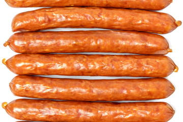 Background of dry sausages. Kabanos sausages folded in a row close-up on a white background.