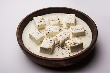 Paneer Dum Kali Mirch / Kalimirch, prepared in a white creamy gravy and black pepper powder sprinkled over it. served in a bowl. Selective focus