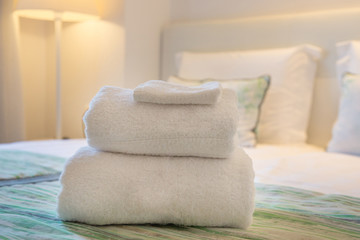 Clean bath towels on bed in hotel suite	