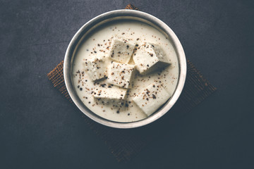 Paneer Dum Kali Mirch / Kalimirch, prepared in a white creamy gravy and black pepper powder sprinkled over it. served in a bowl. Selective focus