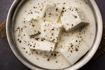 Paneer Dum Kali Mirch / Kalimirch, prepared in a white creamy gravy and black pepper powder sprinkled over it. served in a bowl. Selective focus
