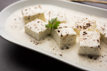 Paneer Dum Kali Mirch / Kalimirch, prepared in a white creamy gravy and black pepper powder sprinkled over it. served in a bowl. Selective focus
