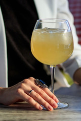 cocktail with ice in a glass in the hands of a girl