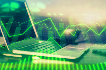 Fototapeta premium Financial graph colorful drawing and table with computer on background. Double exposure. Concept of international markets.