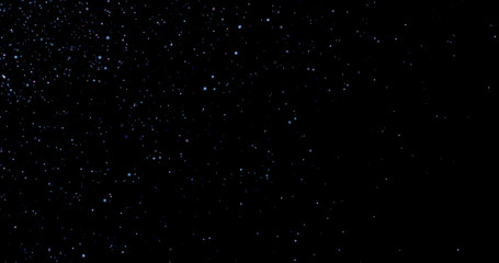 Flying dust particles on a black background