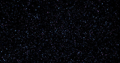 Flying dust particles on a black background