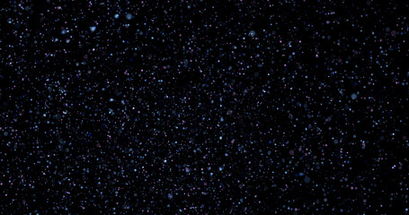 Flying dust particles on a black background