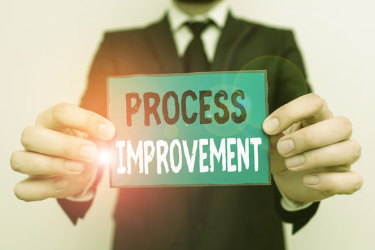 Writing note showing Process Improvement. Business concept for ongoing effort to improve products services or processes Male human wear formal work suit with office look hold book