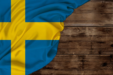 national flag of modern state of Sweden, beautiful silk, background old wood, concept of tourism, economy, politics, emigration, independence day, copy space, template, horizontal
