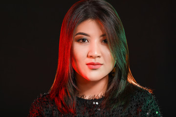 Portrait of young Asian woman on dark background