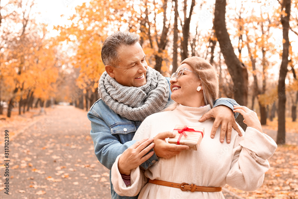 Poster mature man greeting his wife in autumn park