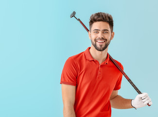 Handsome male golfer on color background