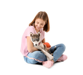 Cute teenage girl with funny husky puppy on white background
