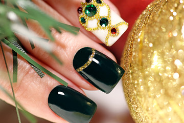 New year's fashionable beautiful festive manicure on short square nails with green lacquer color, with Golden sequins, bouillon and rhinestones of different colors .Christmas nail art.