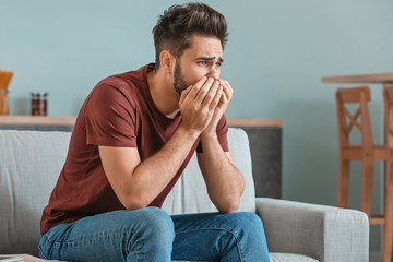 Portrait of worried young man at home