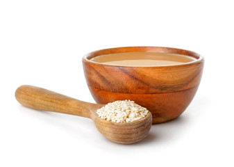 Bowl of tasty tahini on white background