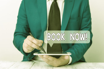 Text sign showing Book Now. Business photo text guaranteed to have place because you have already purchased it Businessman pointing with pen in empty copy space