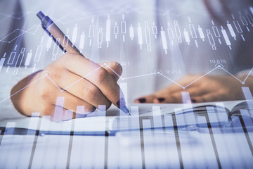Multi exposure of woman's hands making notes with forex graph hologram. Concept stock market...