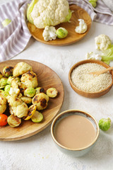 Bowl of tasty tahini and grilled vegetables on table
