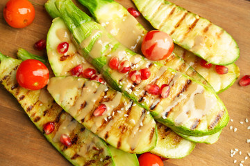 Grilled vegetables with tasty tahini on wooden board