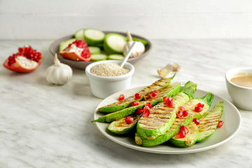 Plate with grilled vegetables and tasty tahini on table