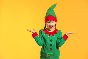 Surprised girl in costume of elf on color background