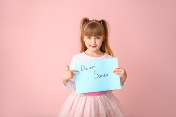 Cute little girl with letter to Santa Claus on color background