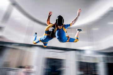 Hobbies. Free people prefere active sports. Bird men conquers sky. Flying people in blue and yellow suit. Extreme as a hobby.