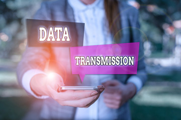 Conceptual hand writing showing Data Transmission. Concept meaning sending data electronically over a communications network Woman in grey suites holds mobile phone